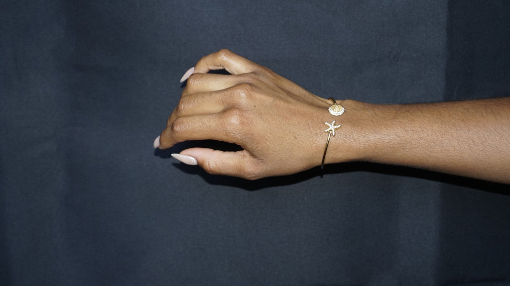 Bracelet ouvert orné d'une étoile de mer et d'un coquillage serti de strass