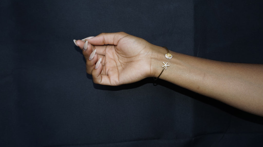 Bracelet ouvert orné d'une étoile de mer et d'un coquillage serti de strass