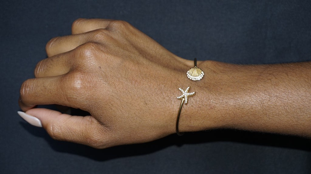 Bracelet ouvert orné d'une étoile de mer et d'un coquillage serti de strass
