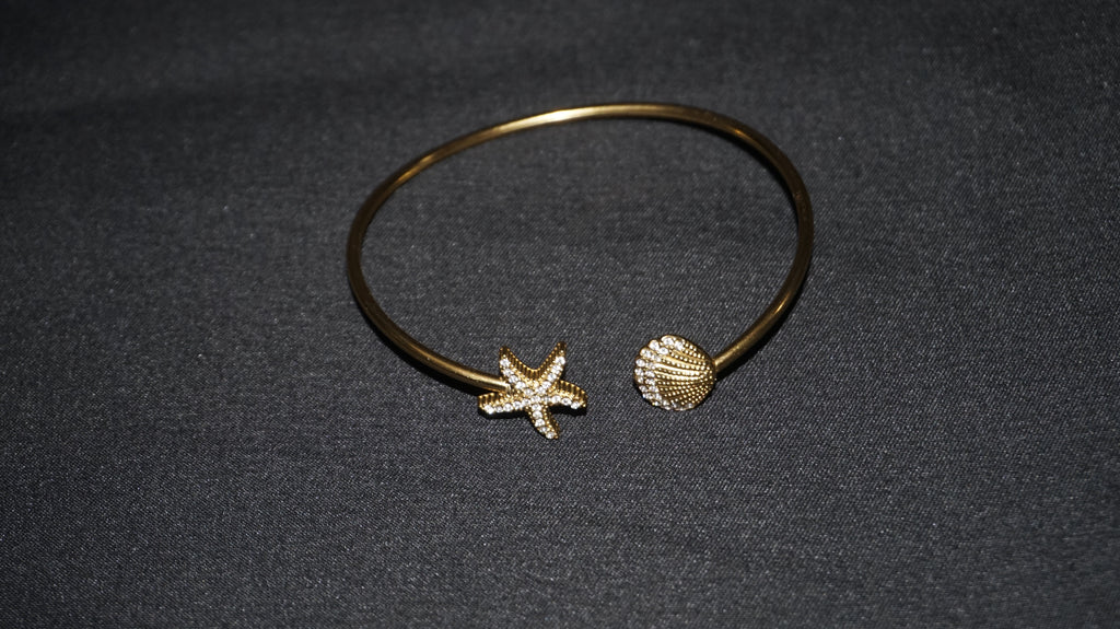 Bracelet ouvert orné d'une étoile de mer et d'un coquillage serti de strass
