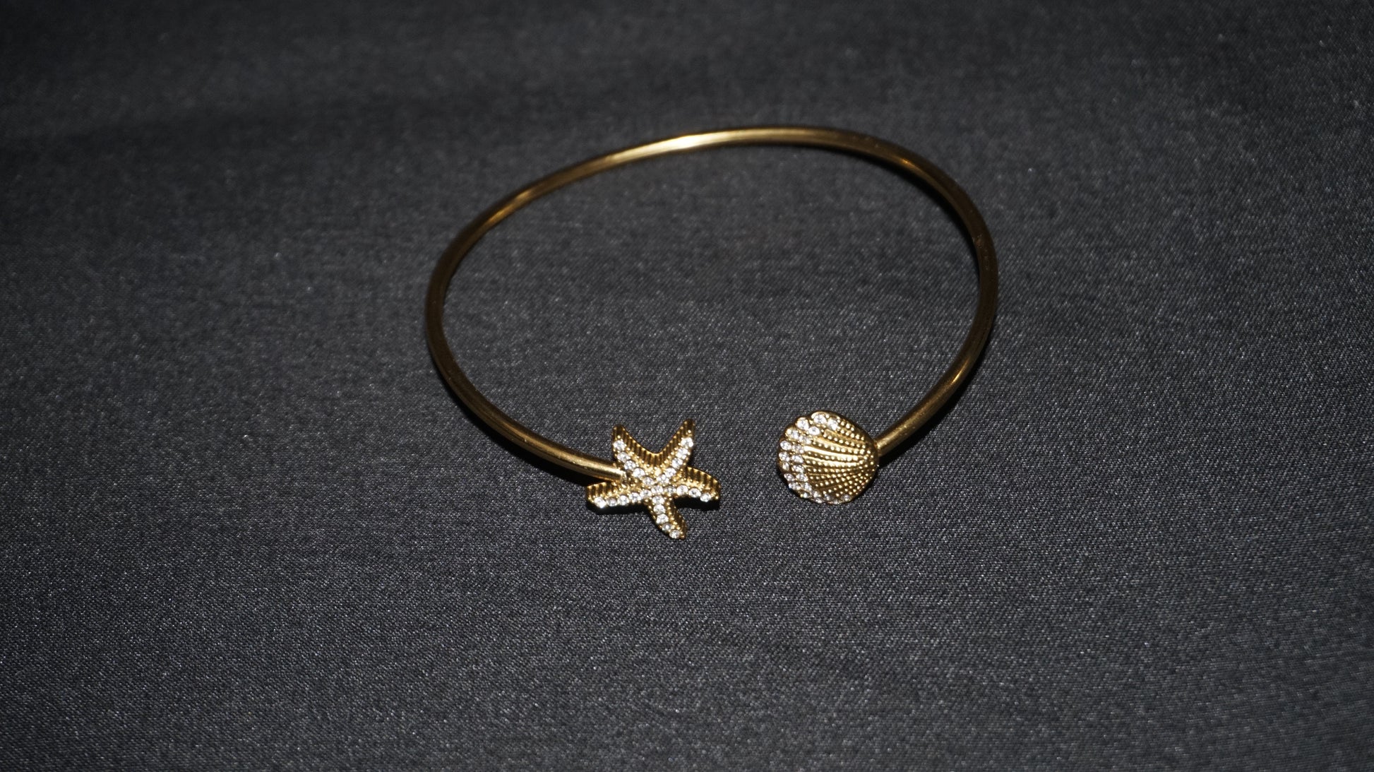 Bracelet ouvert orné d'une étoile de mer et d'un coquillage serti de strass