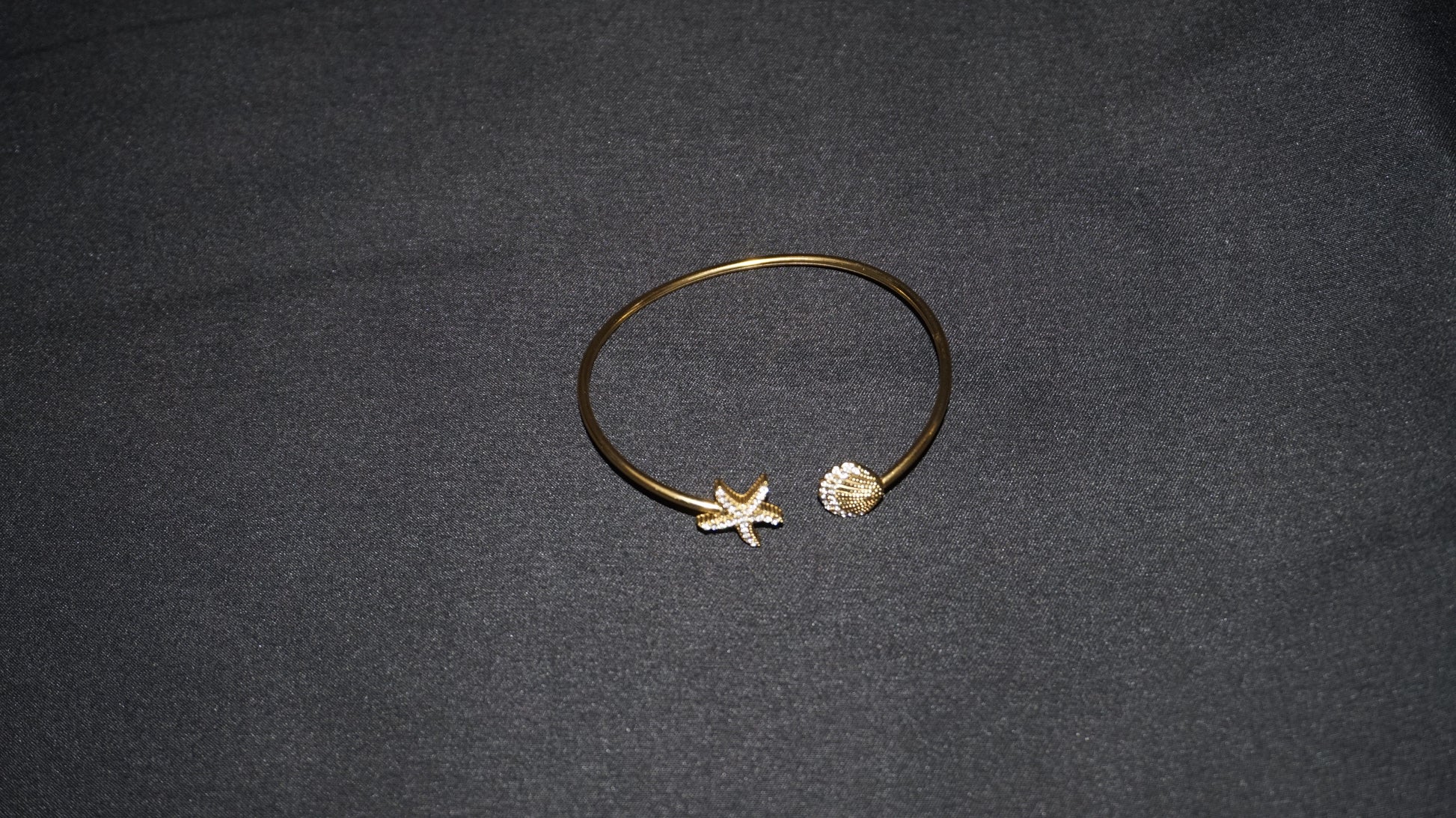Bracelet ouvert orné d'une étoile de mer et d'un coquillage serti de strass