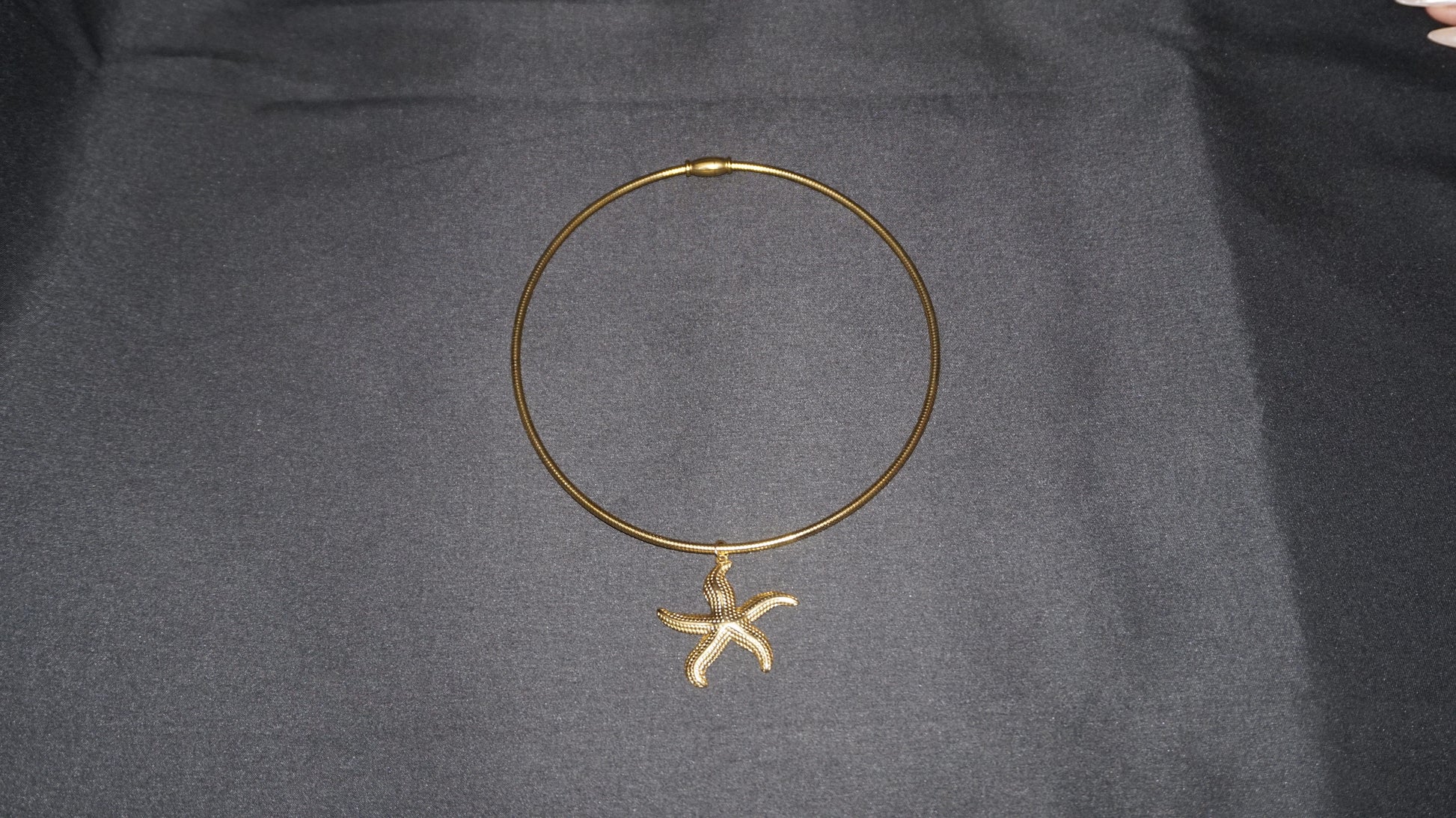 Collier torque doré orné d'un pendentif étoile de mer texturé